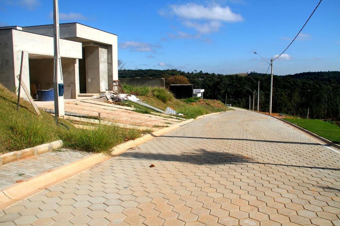 Rua pavimentada e casa em construção